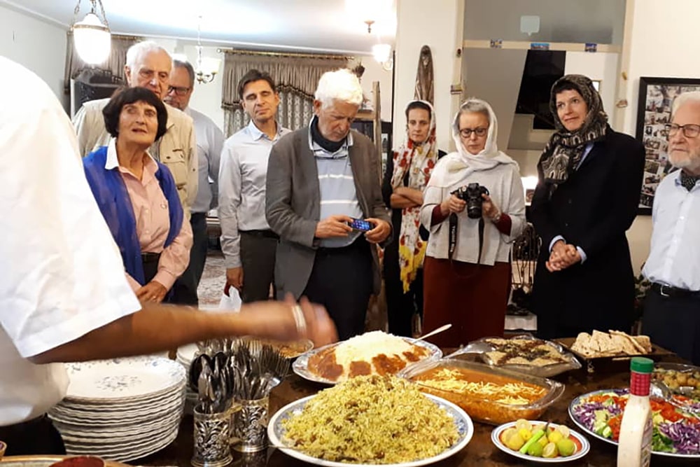 Travelers having dinner at with a local family in Iran